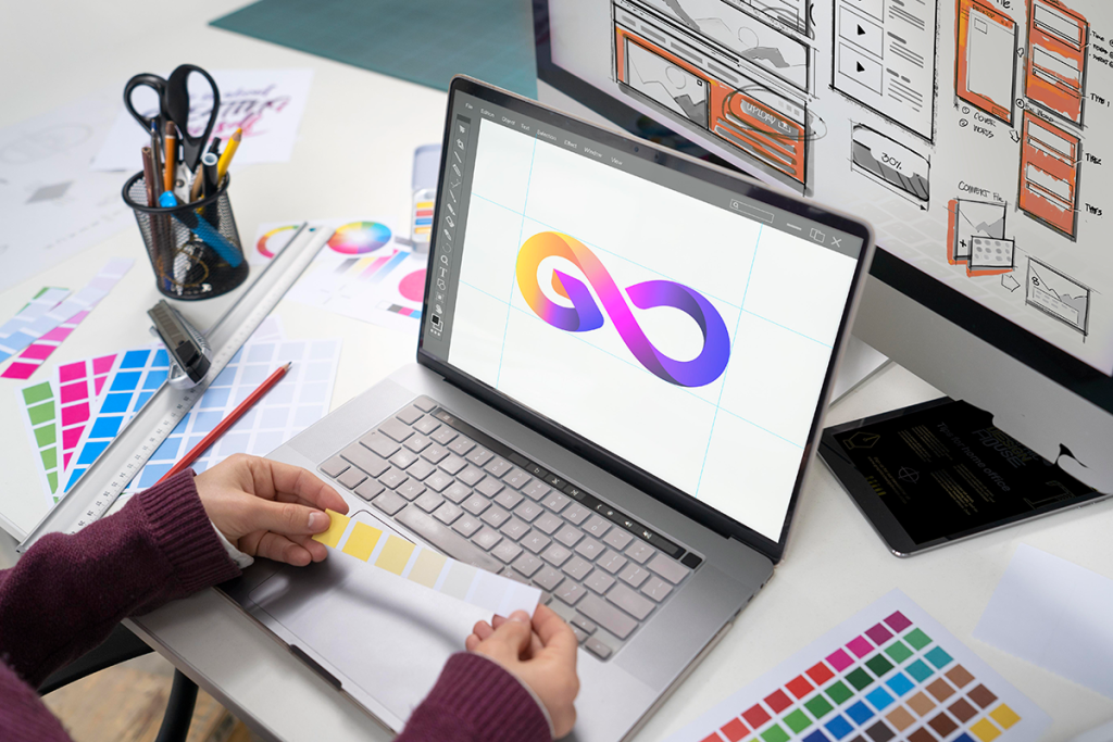 Designer grafico al lavoro su logo, palette colori e interfacce UI per identità visiva aziendale