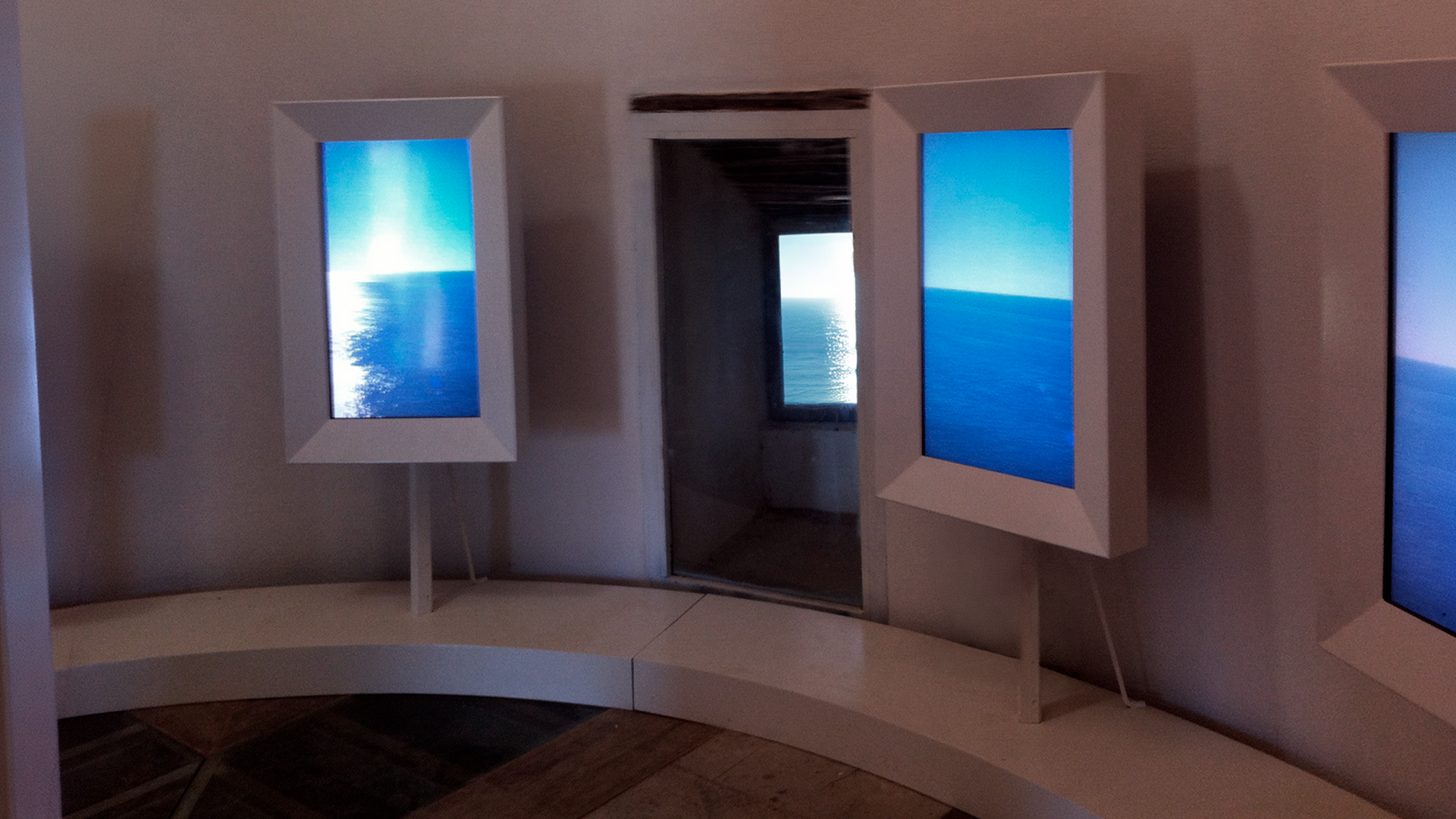 Installazione museale con monitor verticali per percorso multimediale immersivo